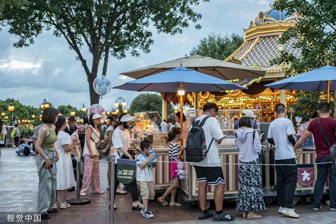2023年7月26日，游客在上海迪士尼乐园购买小食。（图/视觉中国）