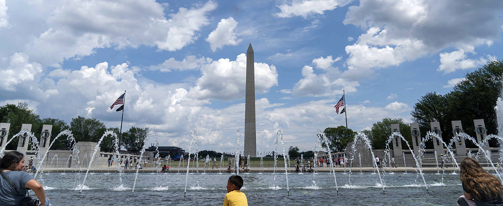 当地时间2023年7月5日，美国华盛顿特区，人们在水池边消暑。
