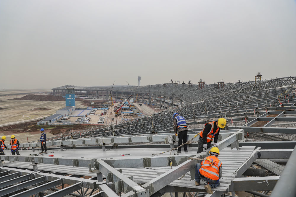 2023年2月16日，施工人员在中建八局承建的重庆江北国际机场T3B航站楼进行屋面作业。新华社发 （范聪 摄）