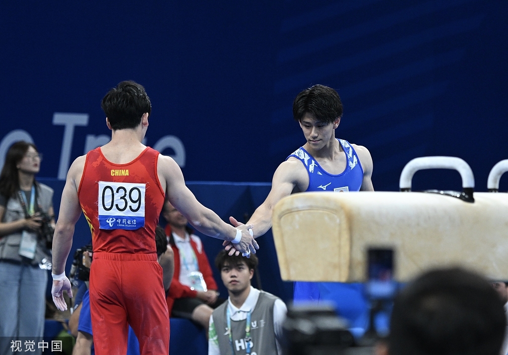张博恒（左）个人体操全能夺金后安慰日本对手。