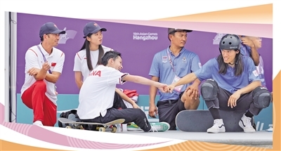 9月25日，泰国代表团选手（前右）向获得滑板项目男子碗池冠军的中国代表团选手陈烨（前左）表示祝贺。本报记者 蒋雨师摄