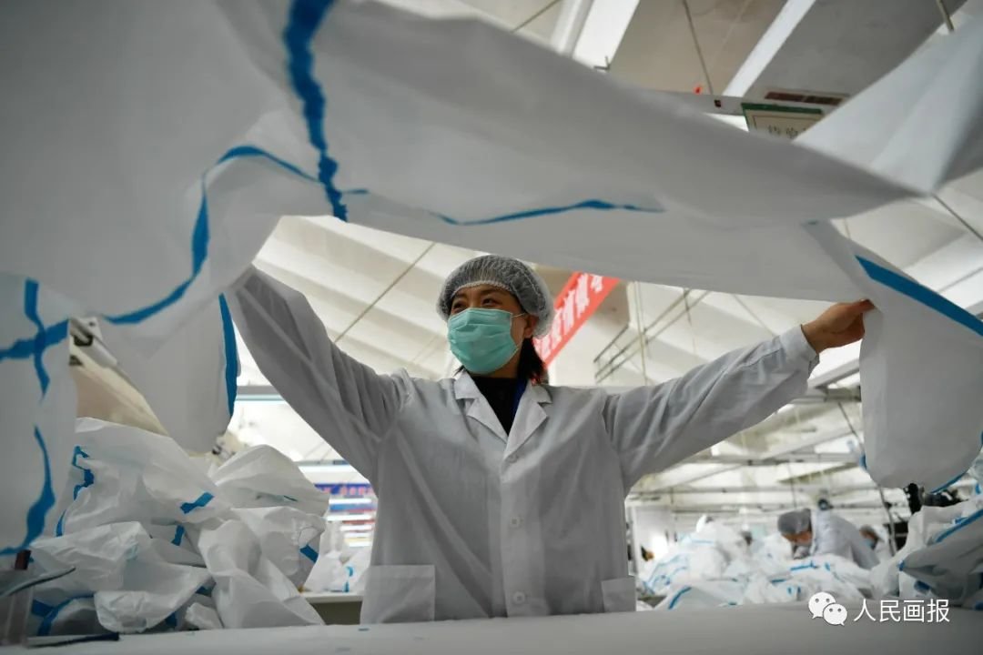 2020年2月17日,河北石家庄,服装厂的工人们在生产线上制作防护服。摄影 翟羽佳/中新社