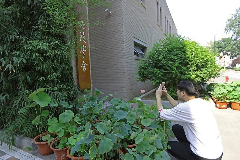 一名青年学子在迦陵学舍前拍照