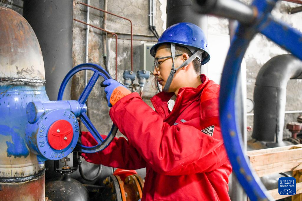 12月23日，在乌鲁木齐市红山路建设厅换热站，乌鲁木齐热力（集团）有限公司第一供热公司技术人员王才在巡检设备，及时调整供热温度。新华社图片