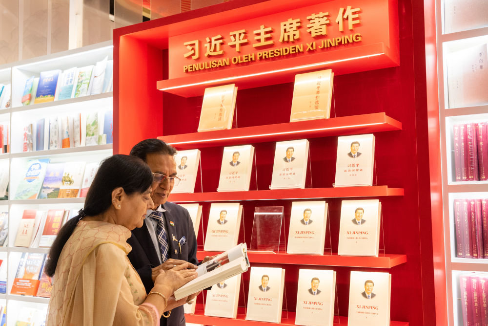 5月30日，印度通用出版社总裁考沙尔·戈亚尔（右）在马来西亚吉隆坡国际书展中国主宾国活动现场阅读习近平主席著作。新华社记者朱炜摄