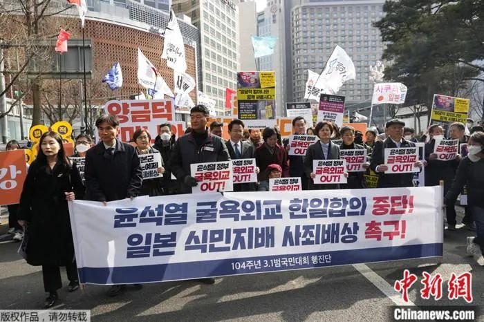 2023年3月1日，韩国民众在首尔日本驻韩大使馆附近集会，举着写有“中断屈辱外交韩日协议”等口号的抗议横幅。