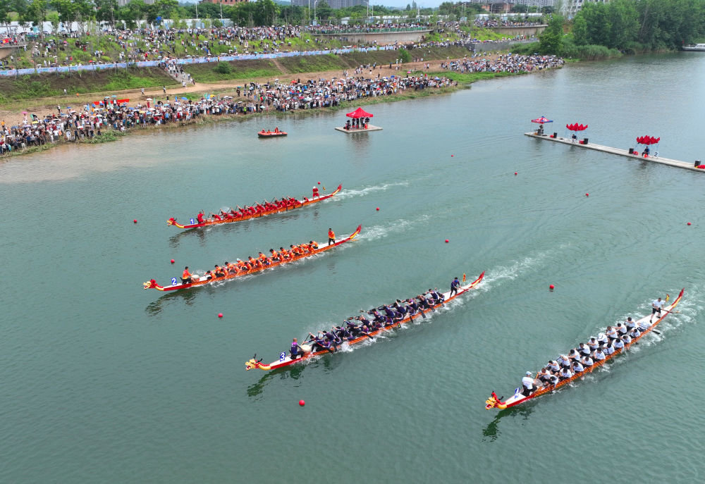 6月17日，在湖南省衡阳市湘江合江套段水域，人们在进行划龙舟比赛（无人机照片）。新华社发（曹正平摄）