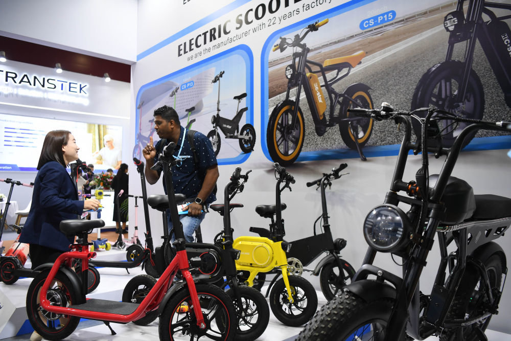 4月15日,采购商(右)和电动自行车参展商在广交会上交流。新华社记者 邓华 摄