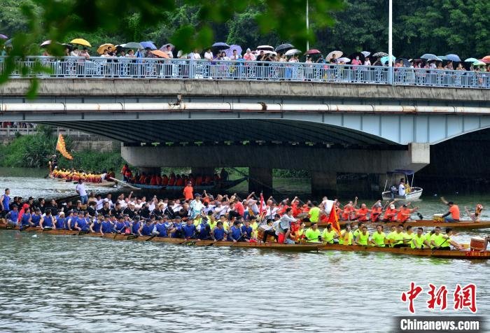 在福州市光明港,民众在划桨竞渡,吸引了许多市民前来观看。 张斌 摄