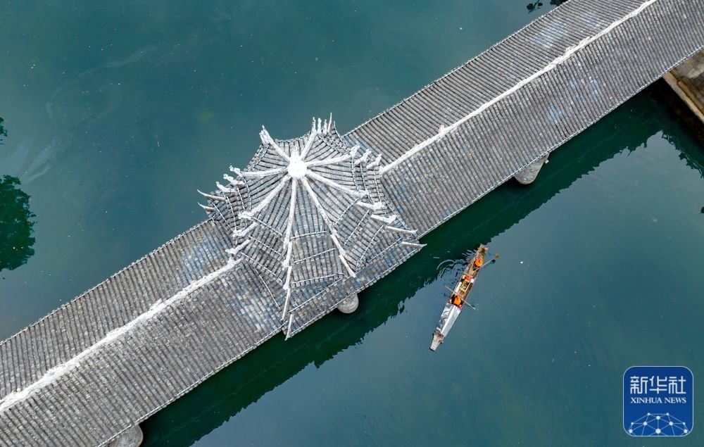 1月21日,湖南省怀化市通道侗族自治县双江镇,环卫工人在江面上打捞漂浮物 (无人机照片)。新华社发(粟勇主摄)