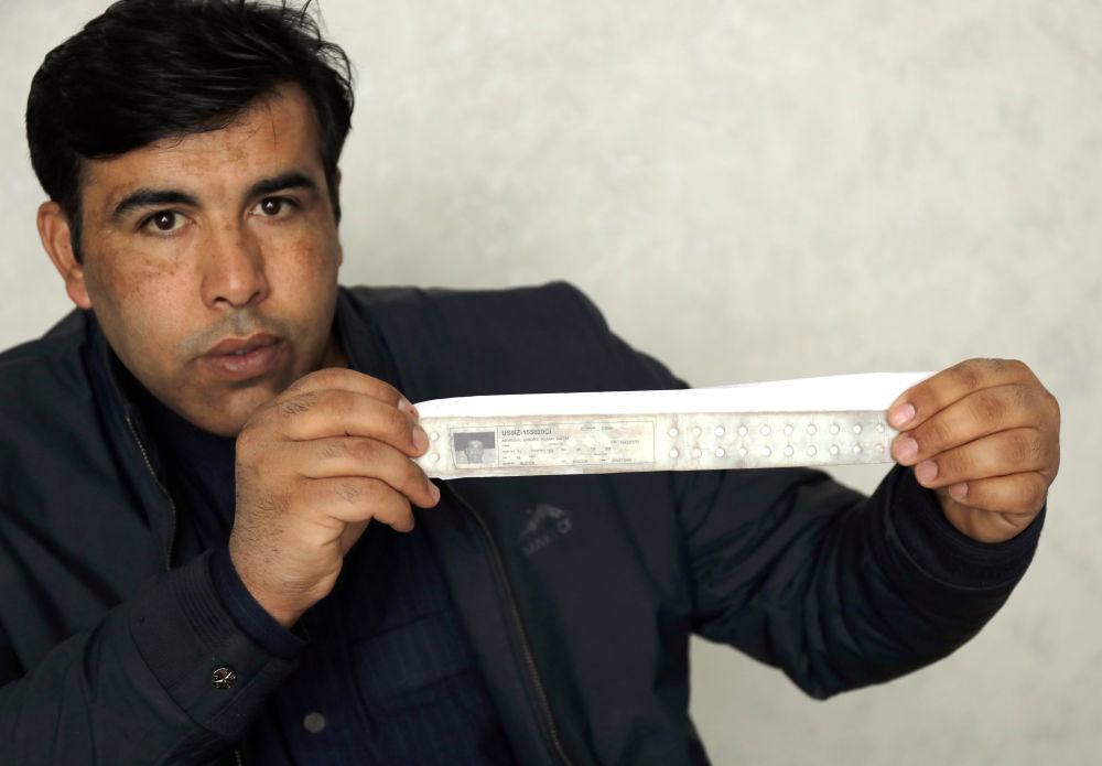 2月17日，在伊拉克北部萨拉赫丁省祖卢耶镇，阿拉&middot;卡里姆&middot;艾哈迈德展示他在被关押期间所戴的印有个人照片和信息的身份识别手环。新华社发（哈利勒&middot;达伍德摄）