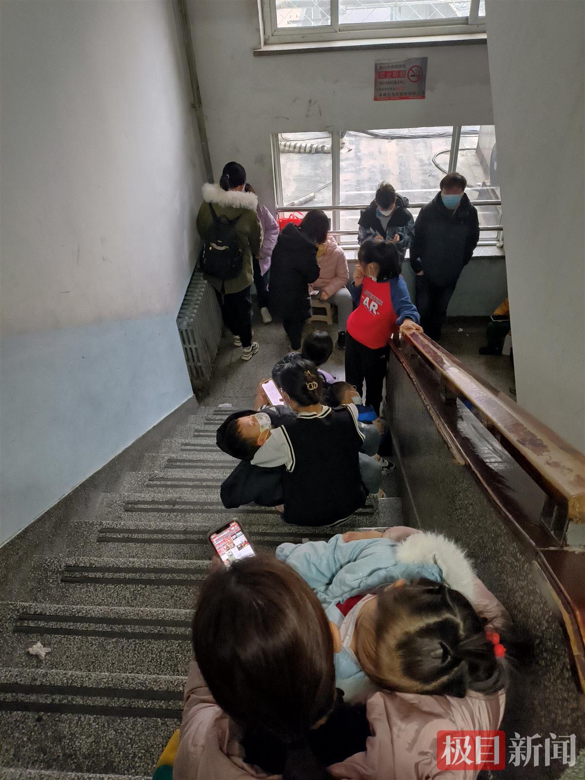 楼梯间坐满了带孩子的家长