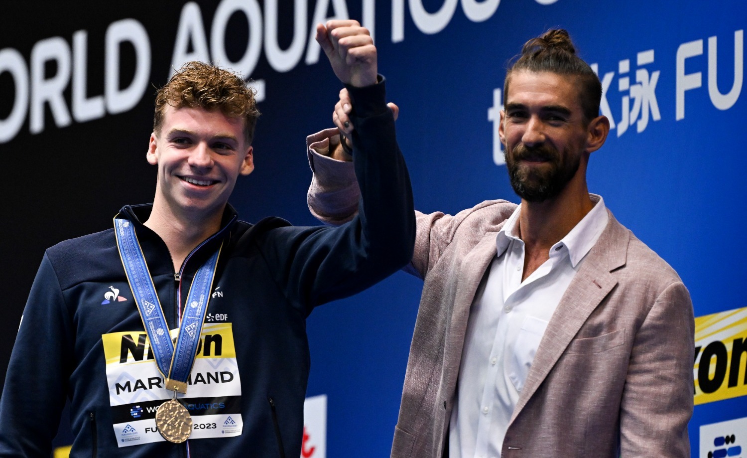 7月23日，法国选手马尔尚 （左）和美国名将菲尔普斯在400米混合泳颁奖仪式上合影留念。新华社记者夏一方摄