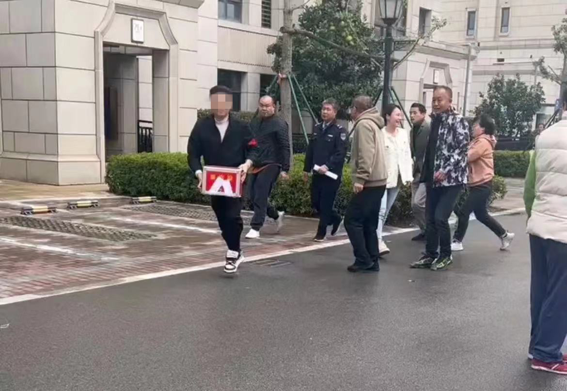 11月12日上午，上海青浦区新华联雅苑小区内，抢夺票箱的男子带着投票箱跑开。受访者 供图