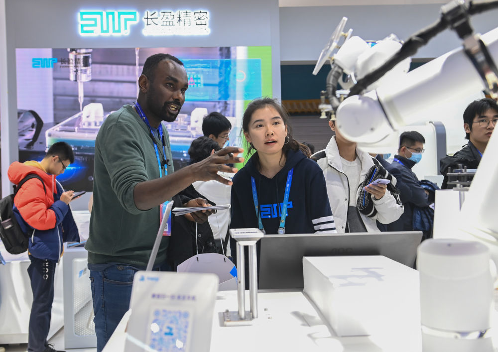 在首届中国国际供应链促进博览会数字科技链展区苹果供应商展位，一名外国客商向参展商咨询（2023年11月29日摄）。新华社记者 蔡湘鑫 摄