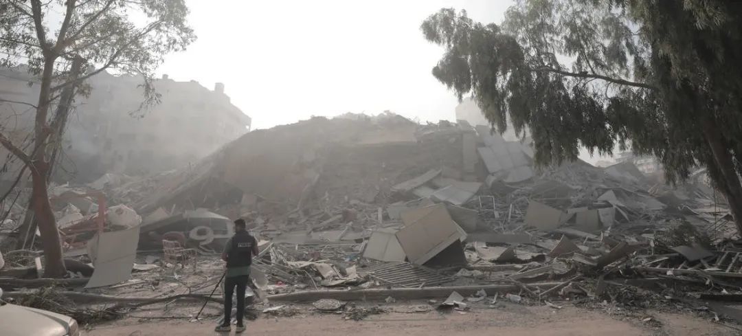 ©近东救济工程处/Mohammed Hinnawi｜一名男子在查看加沙一座倒塌的建筑。