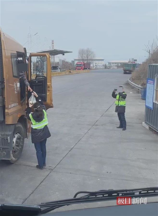 值班人员把饭菜递给司机并拍照(视频截图)