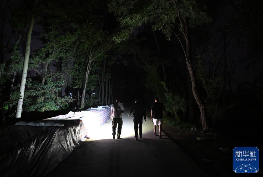 郝庆水（左一）和村干部一起巡视河堤（8月3日摄）。