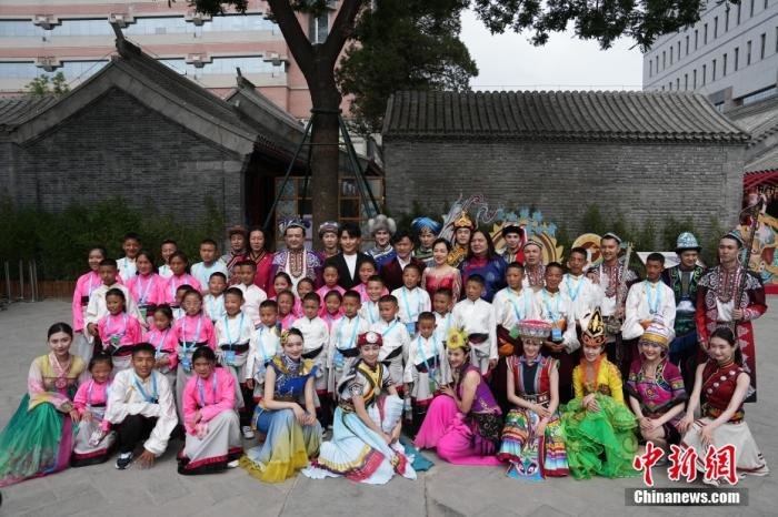 6月1日，来自青海省玉树藏族自治州儿童福利院的40名藏族青少年参观中华民族共同体体验馆。图为孩子们与参加演出的多民族艺术家们合影。 中新社记者 崔楠 摄