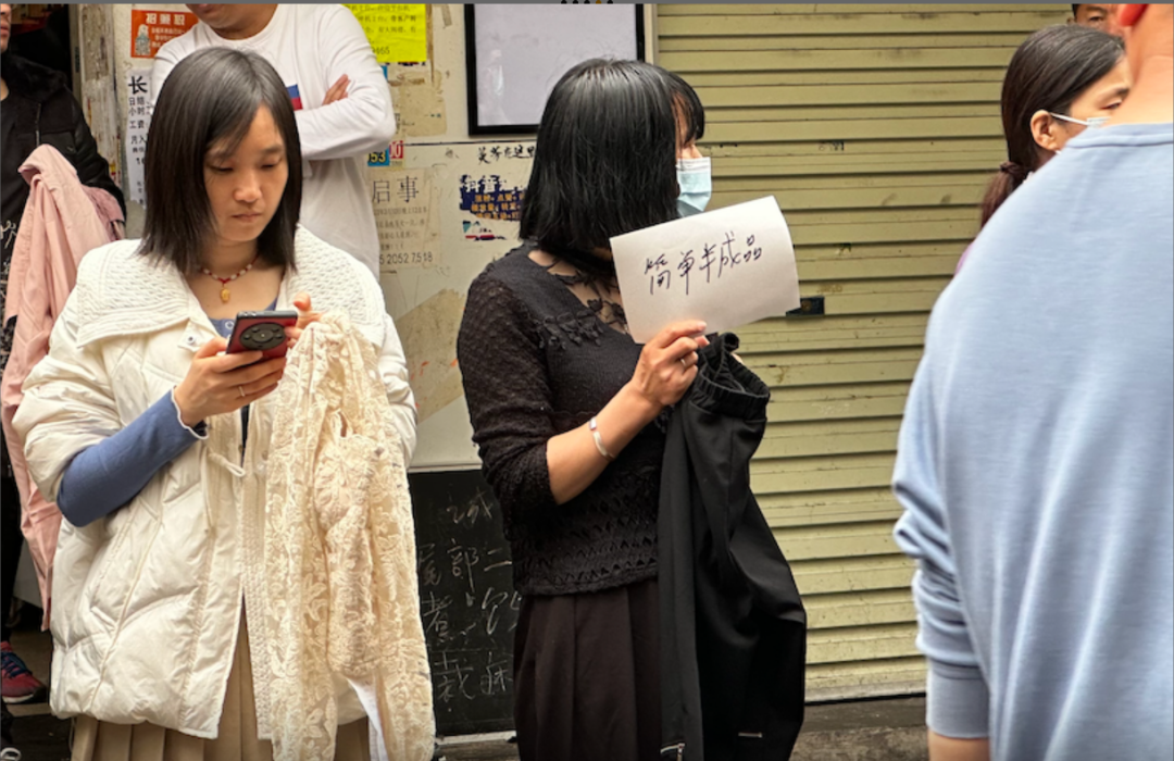 制衣厂老板举着“简单半成品”来吸引来往的工人。图/时代财经王莹岭摄