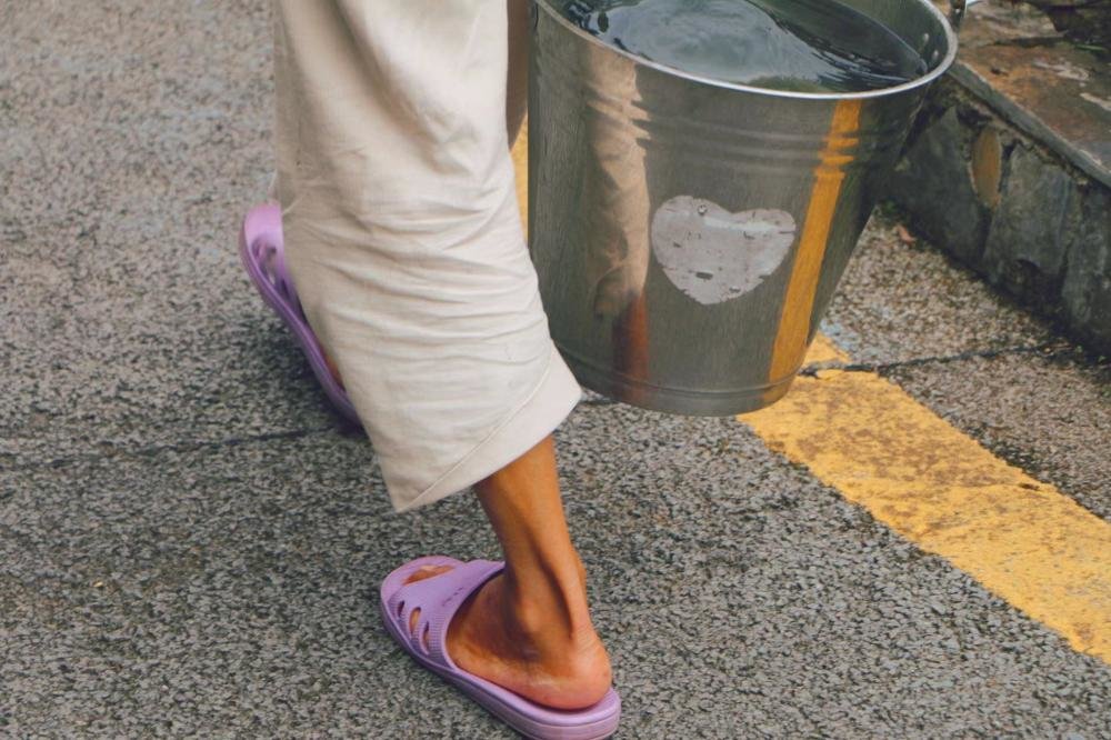 因房车水箱损坏,张瀛只能用铅桶去周边水源处提水。朱雅文 摄