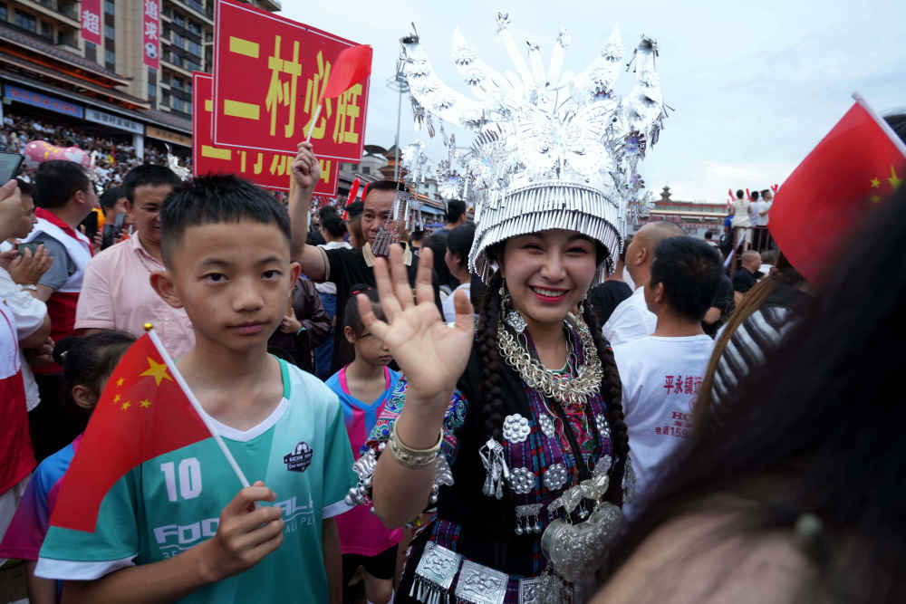 ↑6月23日,村民自发组成的民族歌舞表演队盛装入场。新华社发(王炳真摄)