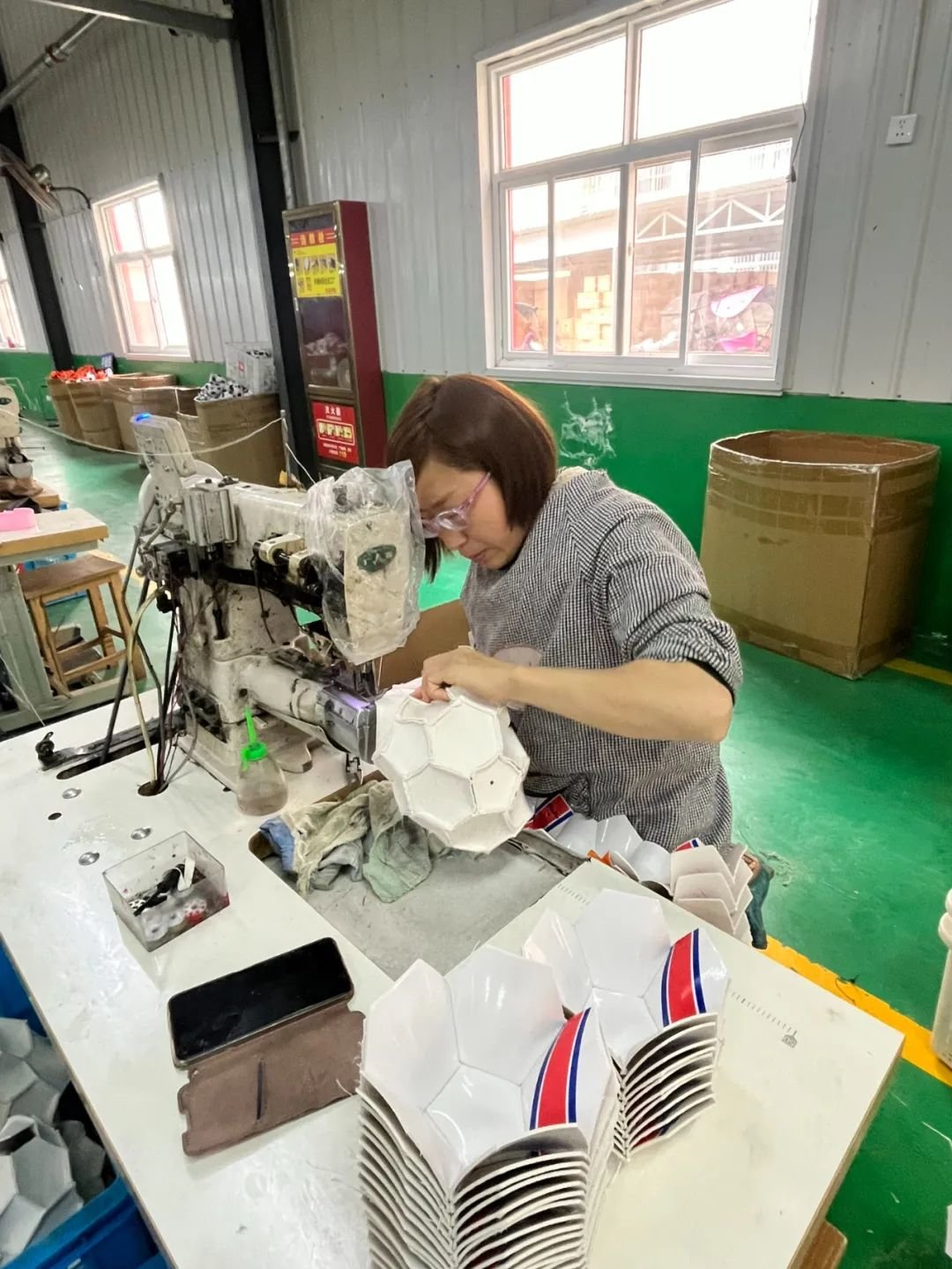 近日,在汉阴县兴隆佳苑社区工厂内,40岁的脱贫户张丽正在“缝制足球”,每月平均收入2600元左右。农民日报·中国农网记者 韩啸 摄