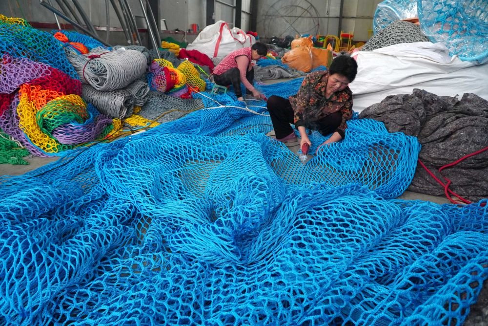 5月5日,在山东省惠民县李庄镇,村民们在绳网小庭院内工作。新华社记者 徐速绘 摄