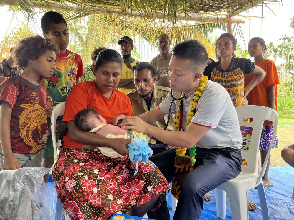 ↑2023年8月5日，在巴布亚新几内亚中央省的一个村庄里，第12批援巴新中国医疗队副队长、新生儿科副主任医师刘振球为一名小病人听诊检查。新华社发（第12批援巴新中国医疗队供图）