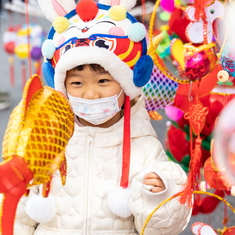 ↑1月25日，在南京夫子庙东牌楼的集市上，小朋友被花灯吸引。新华社发（张梦摄）