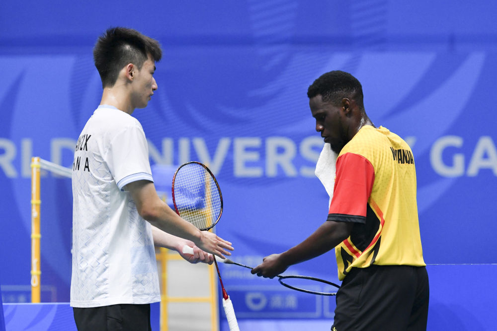 中国选手王正行（左）在比赛后将一支球拍送给阿莫斯。 新华社记者 张端 摄