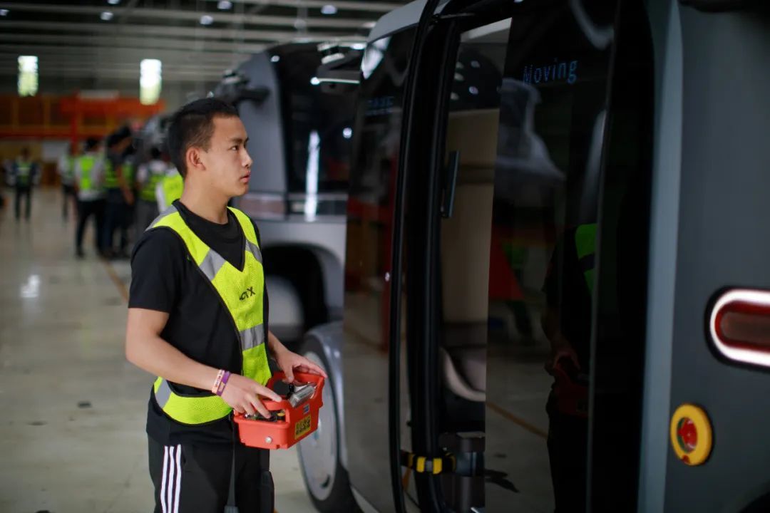 一家无人驾驶汽车企业内，实习生在调试车辆