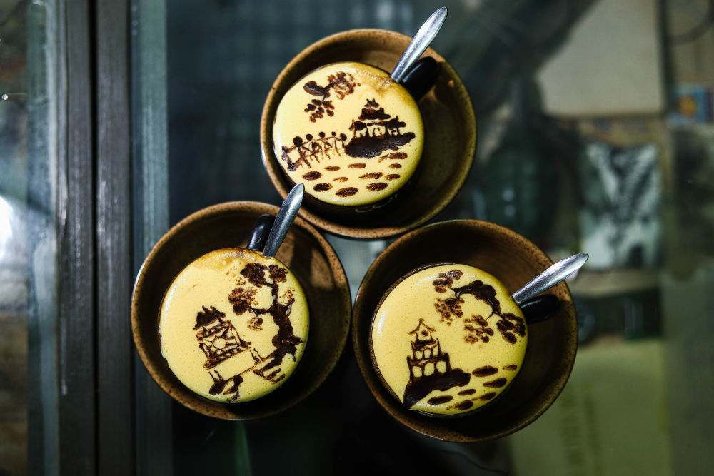 ↑这是2023年7月22日在越南河内一家咖啡店拍摄的绘制河内风光图案的鸡蛋咖啡。越南特色饮品鸡蛋咖啡由蛋黄、糖、炼乳和咖啡等原料制成,其独特的风味受到当地民众和外国游客喜爱。新华社发(范庭德摄)