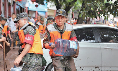 执行救灾任务的武警重庆总队执勤第三支队官兵在搬运物资。刘新吾 李 东摄影报道