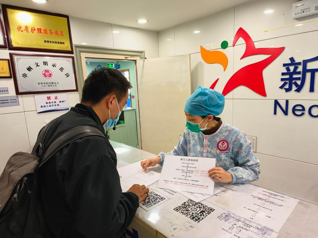 11月22日，昆明市妇幼保健院的工作人员向市民介绍新生儿参保流程。（陈大芝 摄）