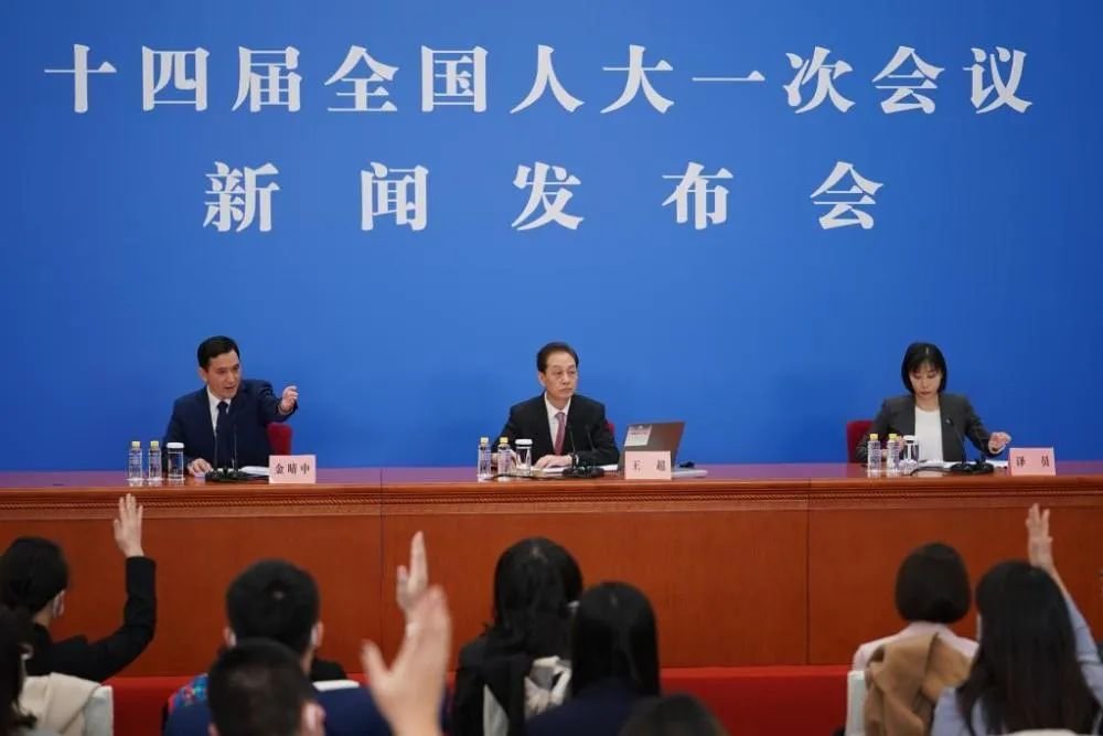 3月4日，十四届全国人大一次会议在北京人民大会堂举行新闻发布会，大会发言人王超（中）就大会议程和人大工作相关问题回答中外记者的提问 图：新华社