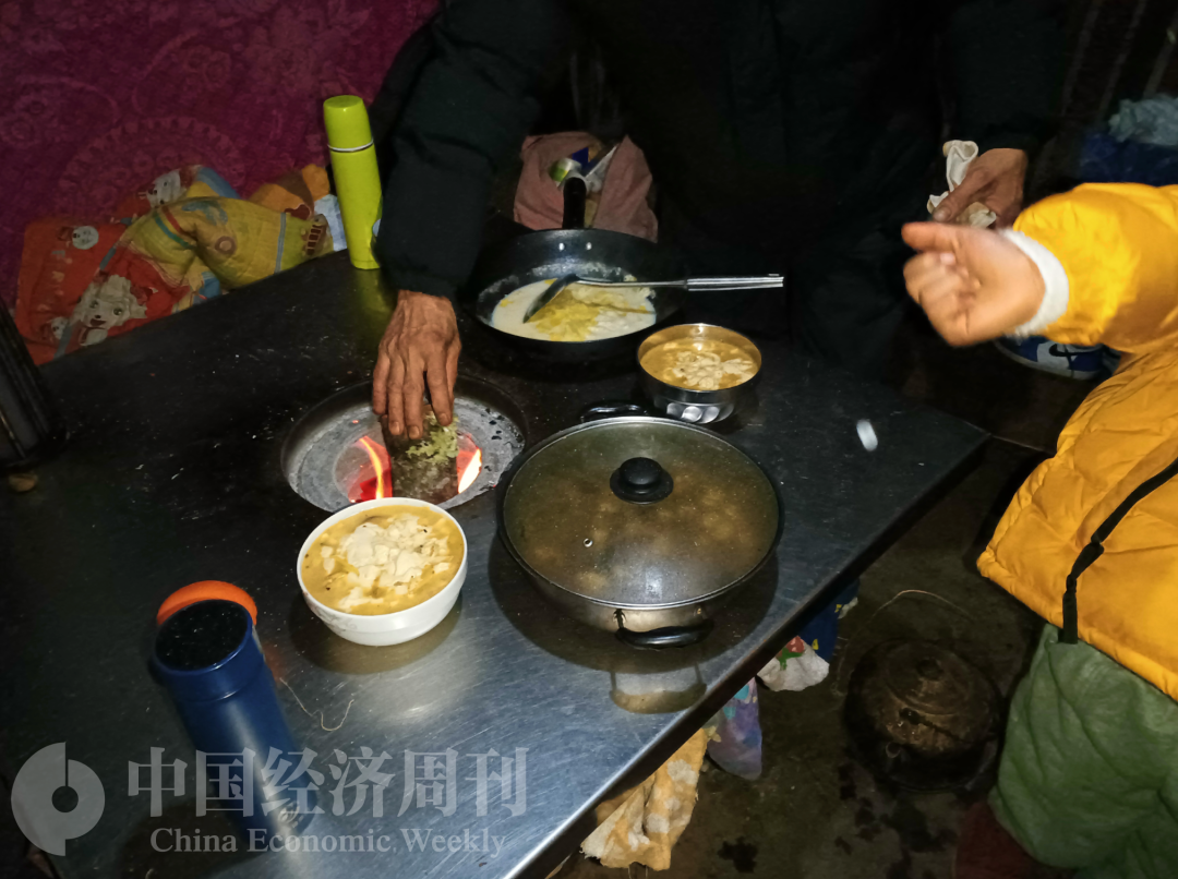 家中唯一的取暖设备,每半小时要加一次柴火。摄影:《中国经济周刊》记者 石青川