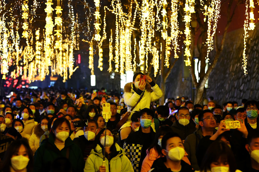 1月22日，游客在西安大雁塔北广场上的诗词灯组下游玩拍照。新华社记者 刘潇 摄