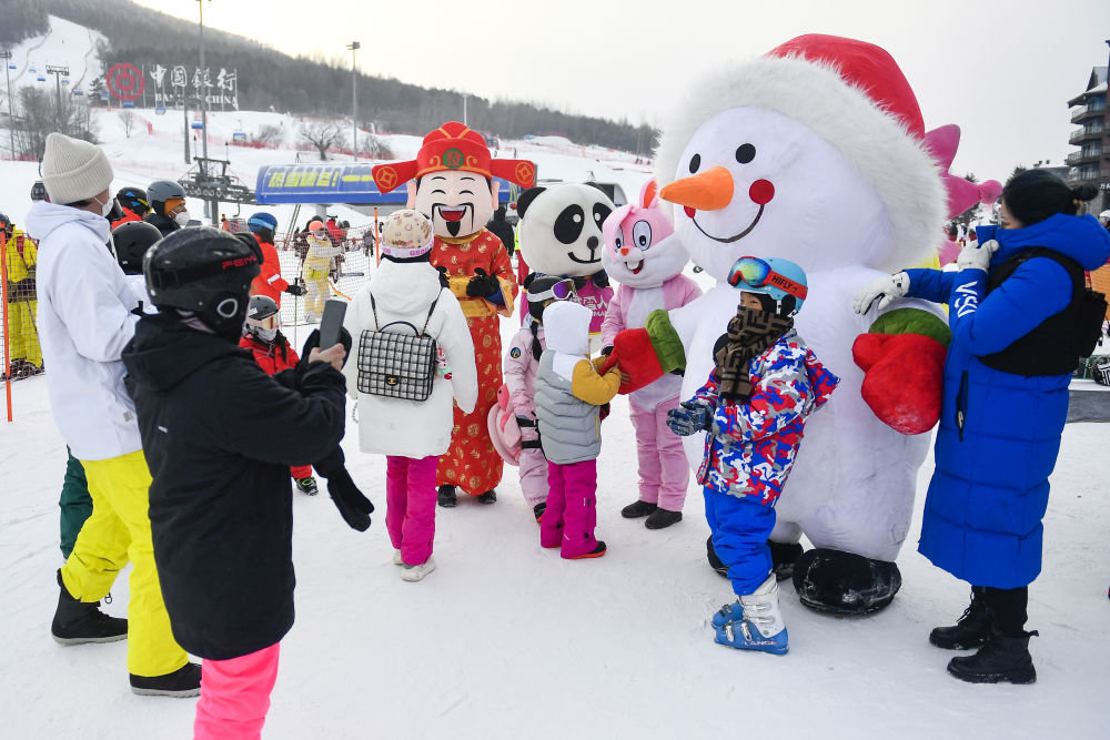 ↑在吉林市万科松花湖度假区，小朋友们与卡通人偶互动（1月23日摄）。新华社记者 许畅 摄