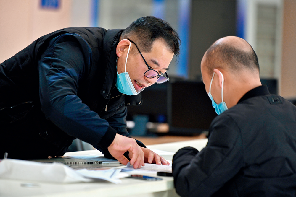 在福建省福州市马尾区政务服务中心，工作人员在前台为市民办理业务（2023年2月21日摄）周义摄 / 本刊