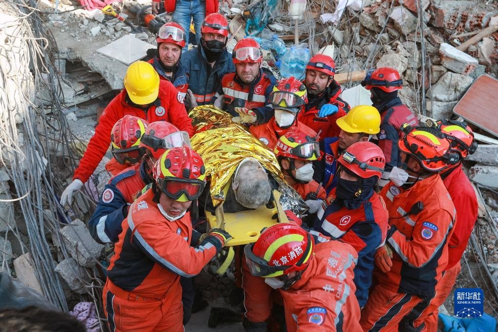 中土两国救援队队员在土耳其哈塔伊省安塔基亚市转移一名救出的幸存者（2023年2月12日摄）。新华社发（穆斯塔法·卡亚摄）