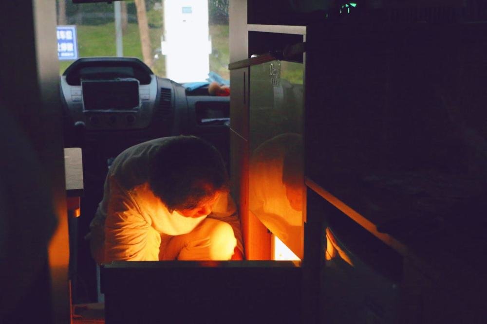 张瀛正打开房车内的冰箱,准备做饭的食材。朱雅文 摄