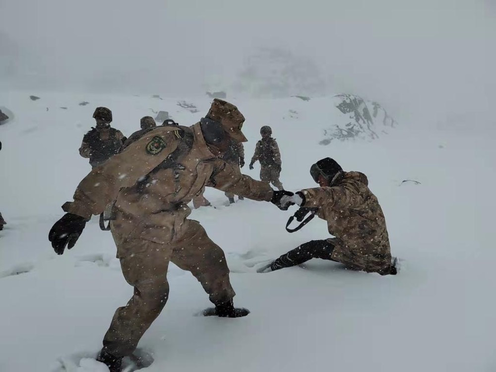 2022年“新春走基层”活动中,中央广播电视总台记者(右一)和官兵一同在海拔近5000米的边防线巡逻 图源:新华社