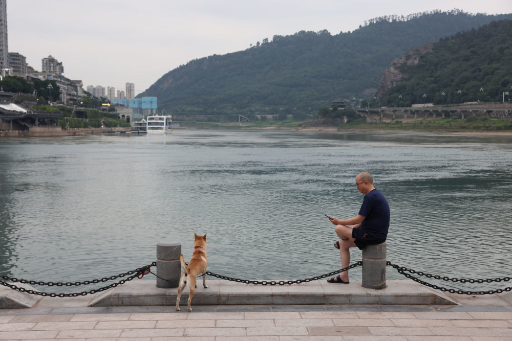 ↑市民在宜宾市三江口江边休息。