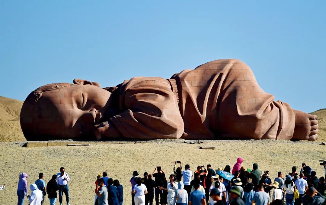 9月8日，甘肃酒泉市瓜州县戈壁国际雕塑艺术长廊上，游客在大型雕塑《大地之子》前游览。摄影/本刊记者 李亚龙