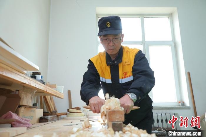 图为梁军使用刨子刨平木头表面。 周悦翔 摄