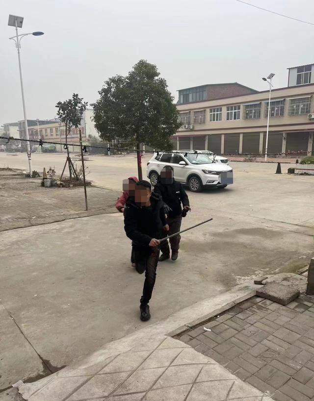 董某拿着钢管。图源:受访者供图。