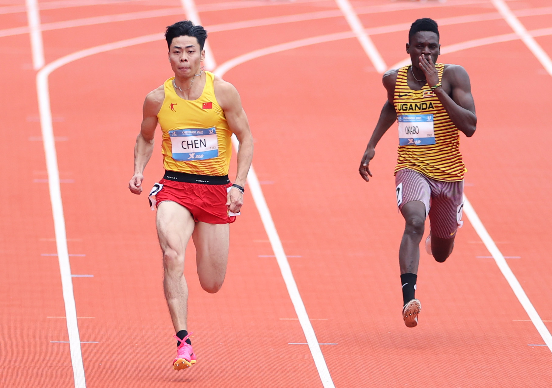 8月1日，陈冠锋（左）在成都大运会田径男子100米预赛中。新华社记者 贾浩成 摄