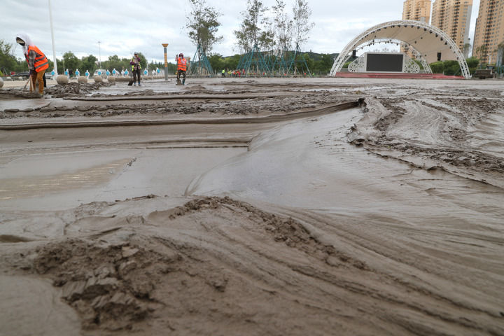 8月11日，在黑龙江省尚志市尚志大街附近，环卫工人在清理淤泥。新华社记者 张涛 摄
