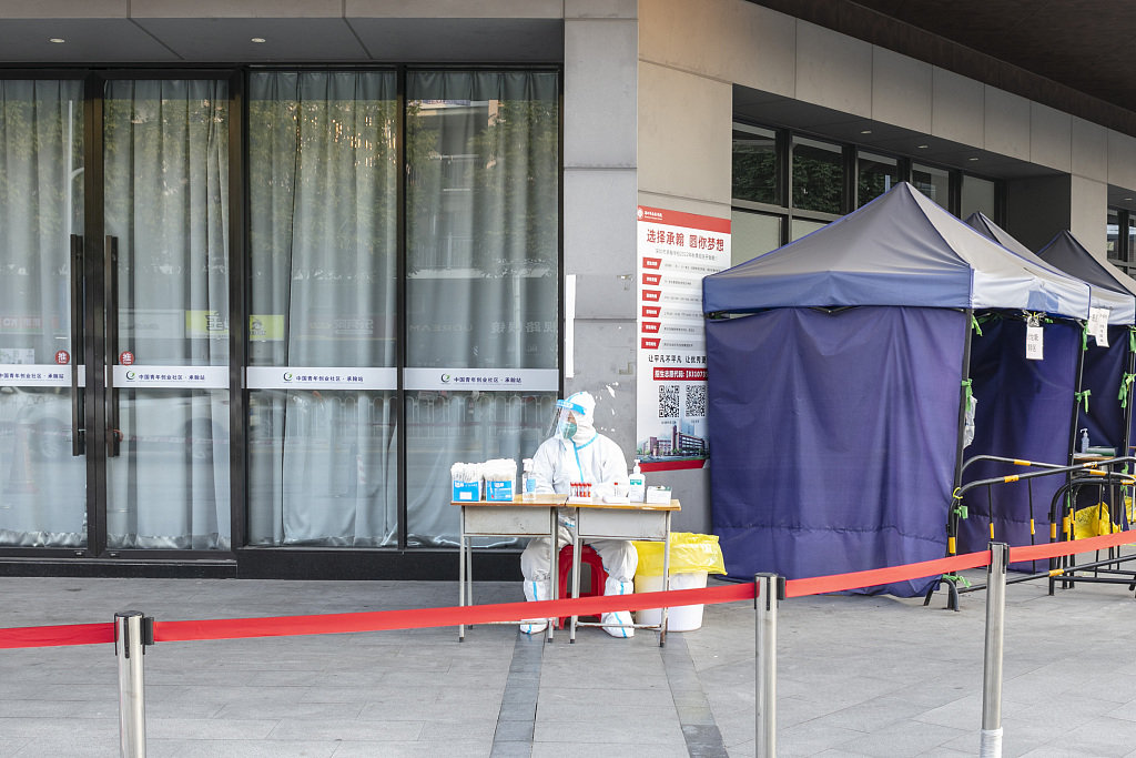 2022年12月30日,深圳街头一核酸检测釆样点,医务人员等待市民做核酸检测。人民视觉 图